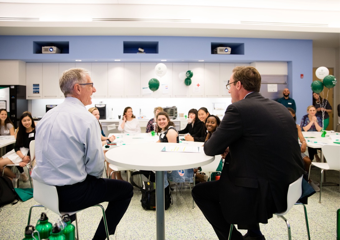 Two corporate men talk to IIG students