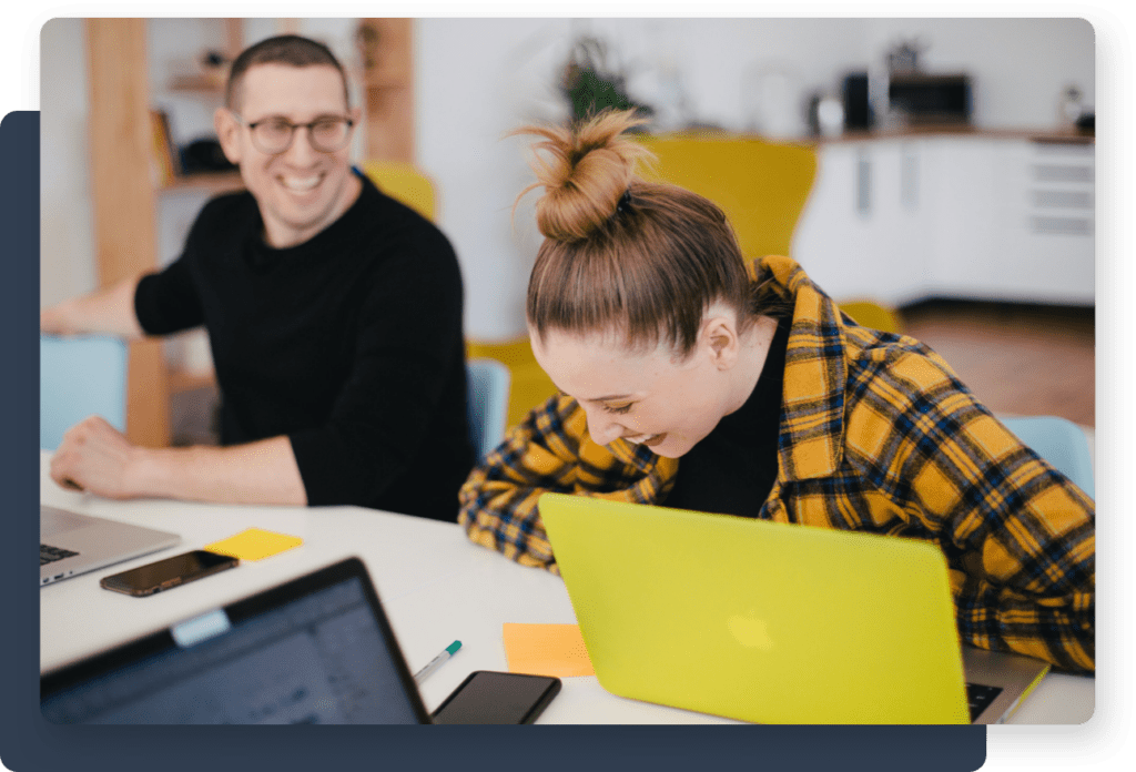 Two people studying and laughing at a computer